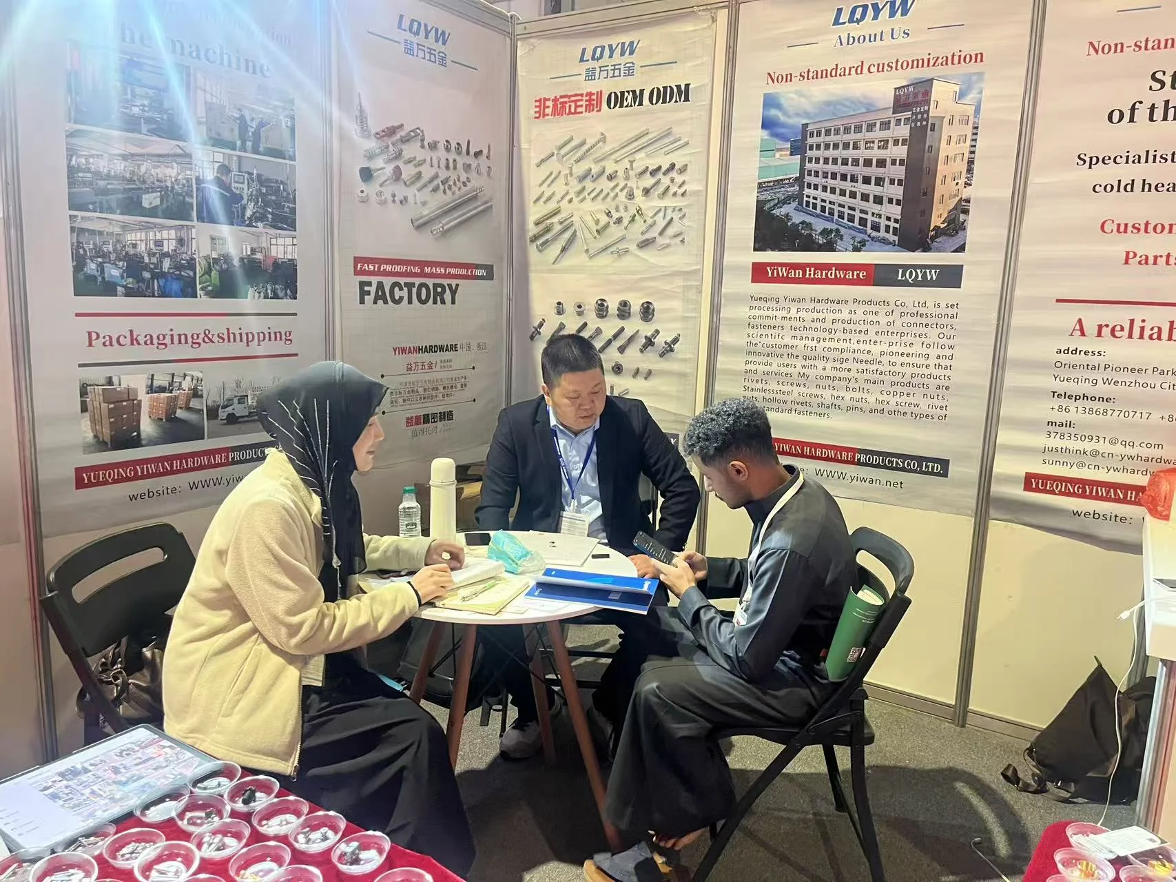 YIWAN team reviewing hardware samples with visitors at the January 2025 Saudi Arabia exhibition